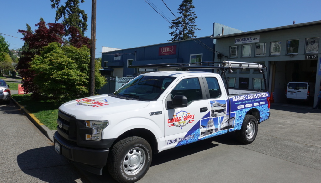 Angled View of White Truck with Digitally Printed Vehicle Graphics Advertizing Canvas Supply Awnings